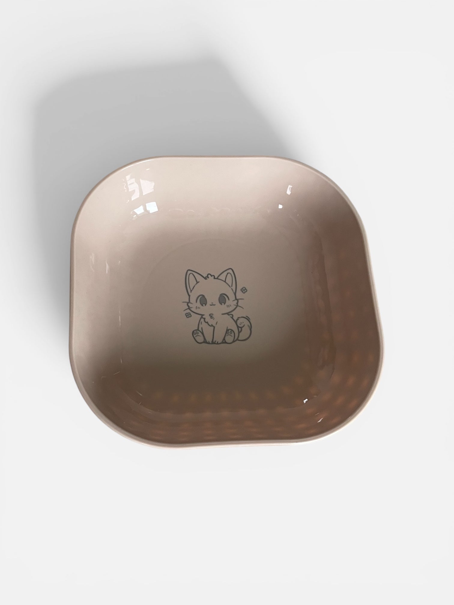 Beige ceramic bowl with a cat illustration on a white background