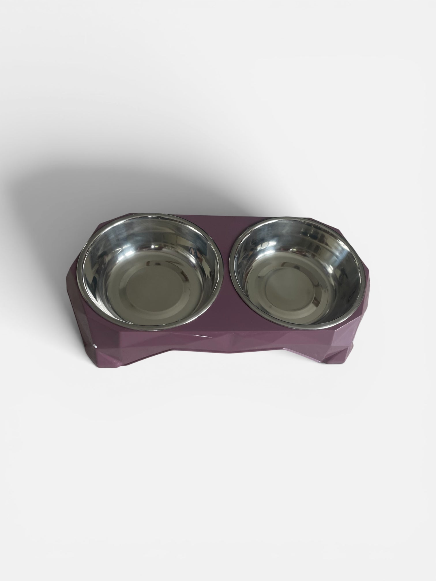 Pet food bowl with two stainless steel bowls on a purple base against a white background