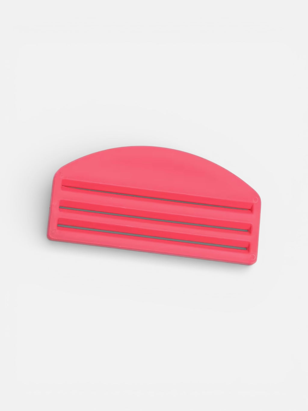 Pink hair clip on a light gray background