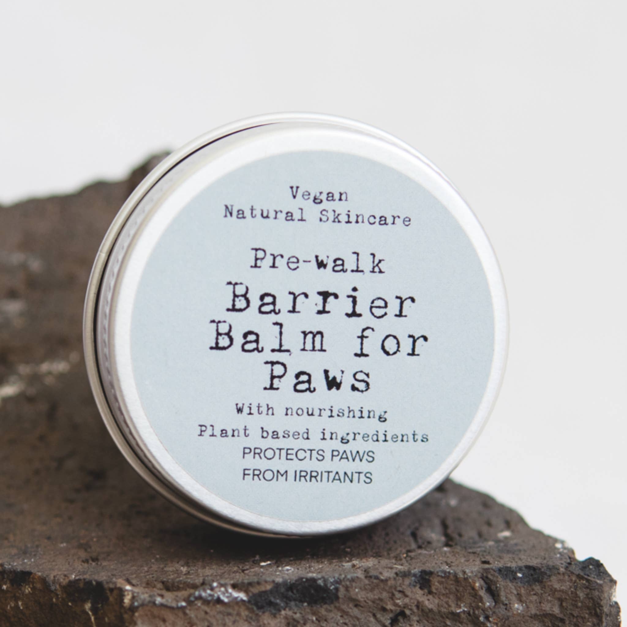 Pre-walk Barrier Balm for Paws on a rock with a neutral background