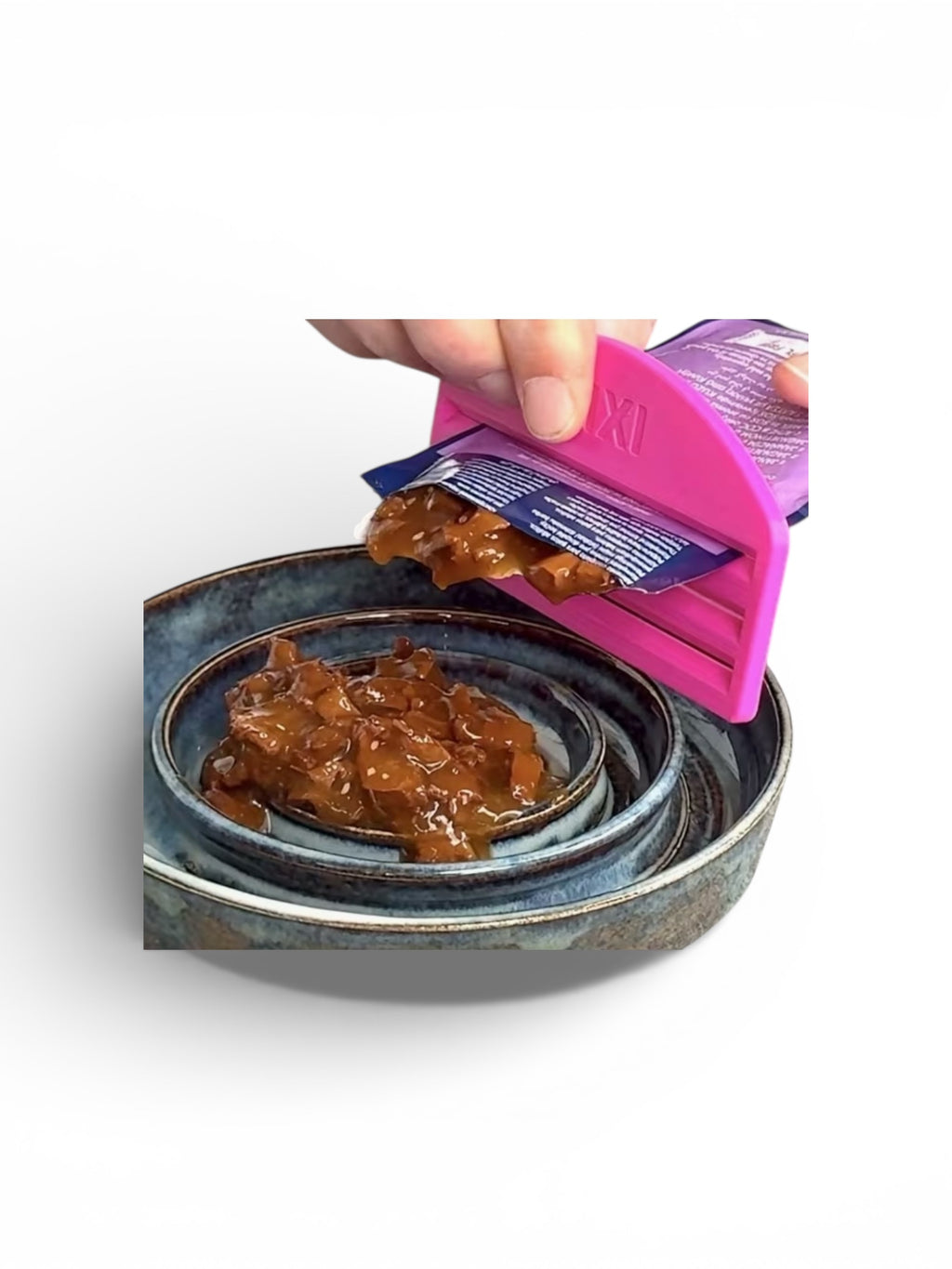 Person using a pink pet food scoop to portion out wet dog food from a container.