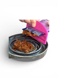 Person using a pink pet food scoop to portion out wet dog food from a container.