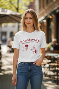 Woman wearing a white t-shirt with 'DOGS & WINE make everything fine' text and graphics outdoors.