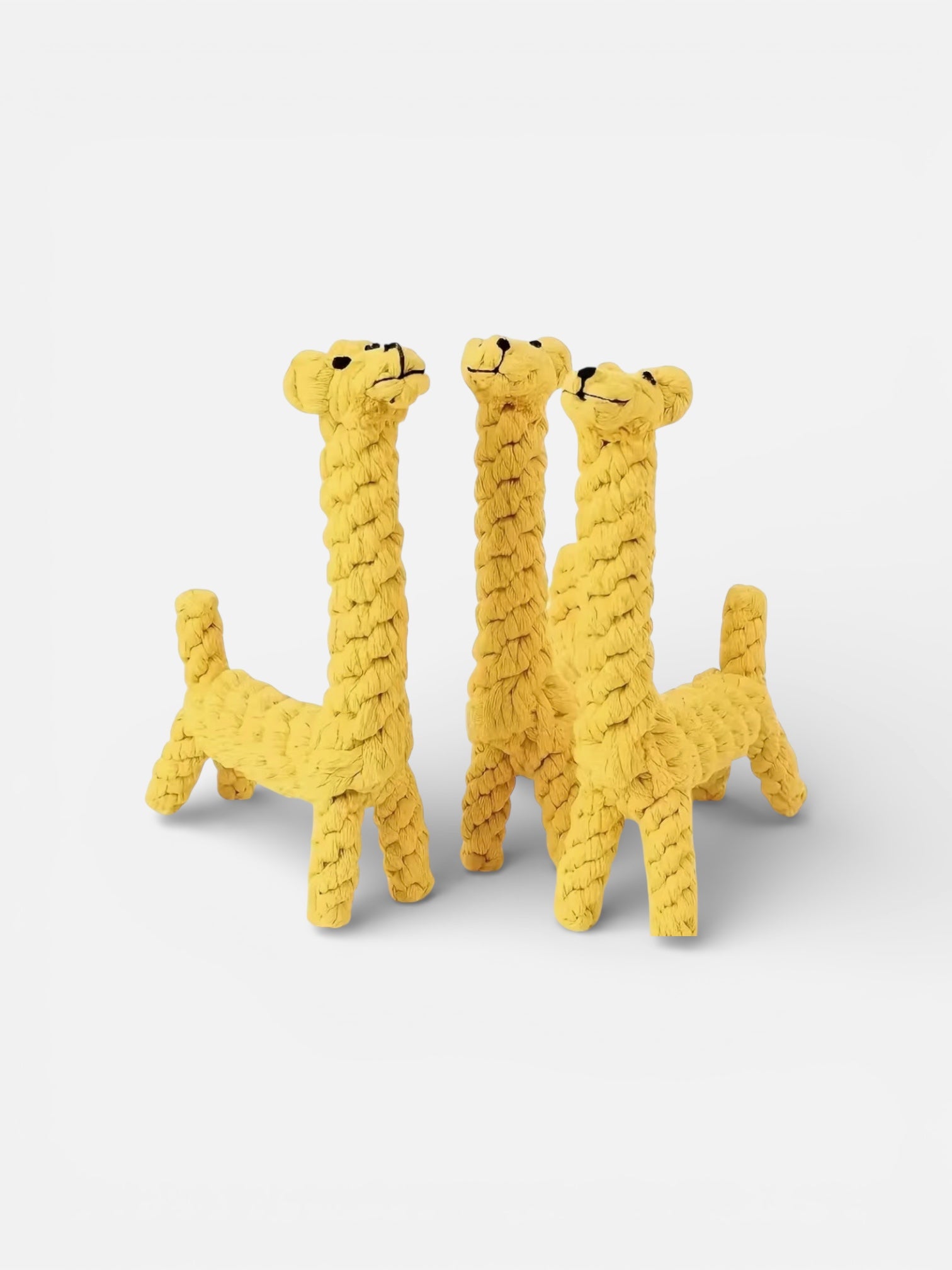 Three yellow giraffe-shaped rope toys on a white background