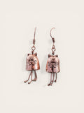 Copper cat-shaped earrings on a light beige background