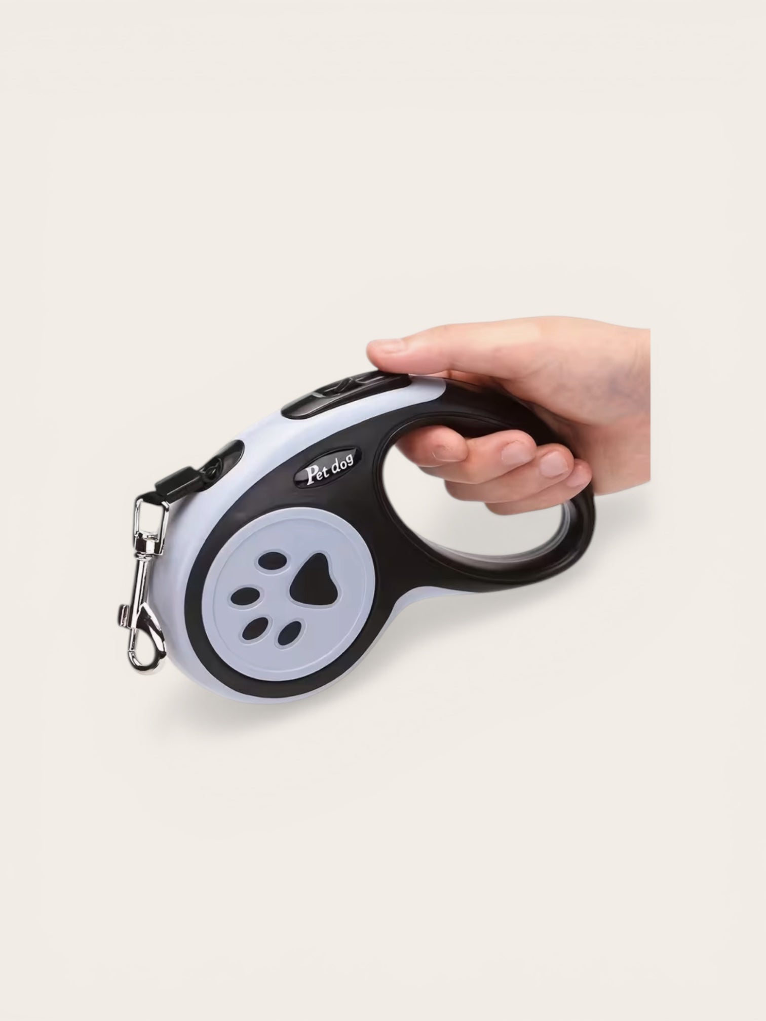 Hand holding a retractable dog leash with a paw design on a white background