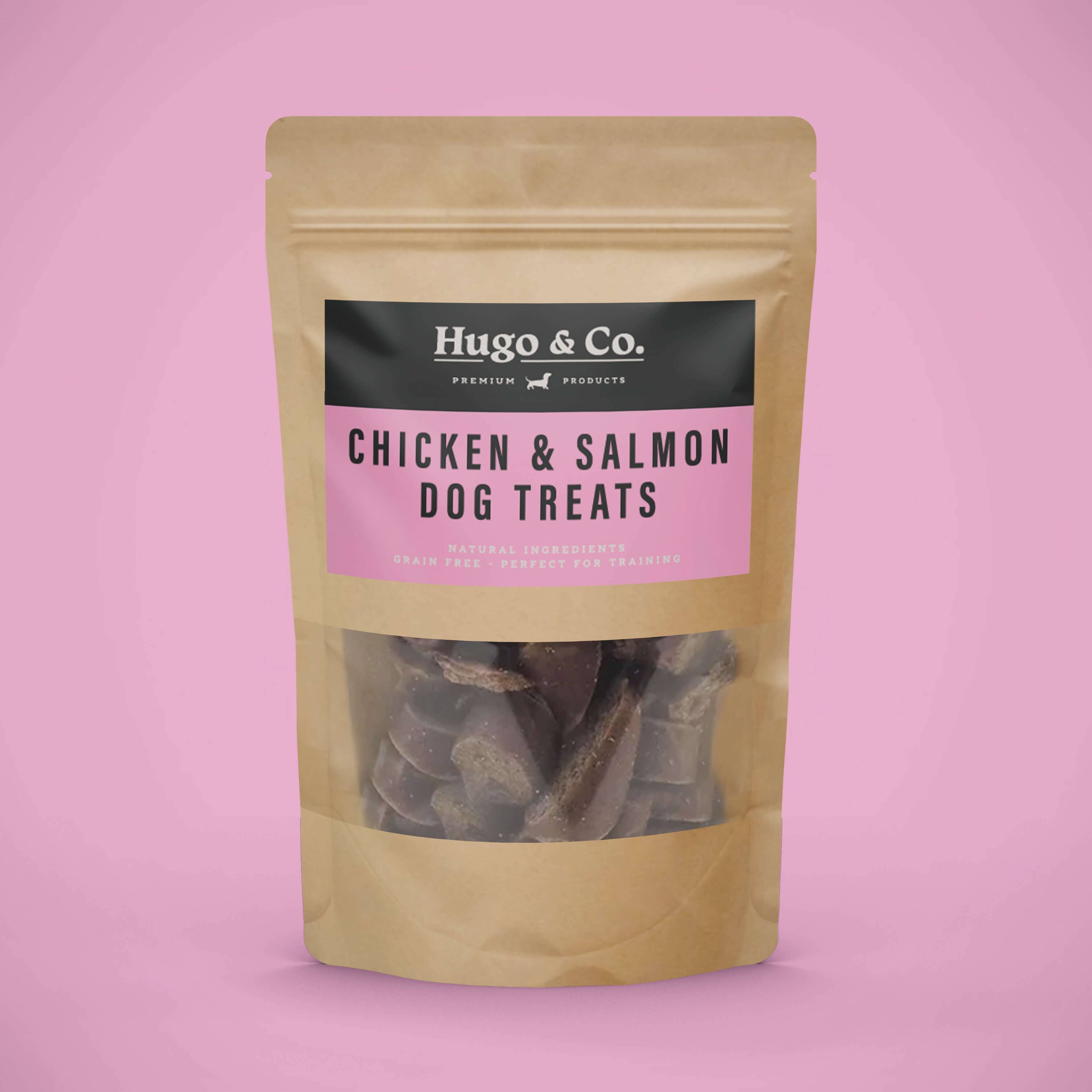 Package of Hugo & Co. chicken and salmon dog treats on a pink background